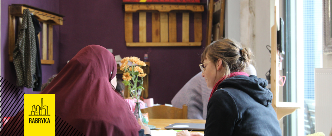 Zwei Frauen sitzen an einem Tisch und unterhalten sich.